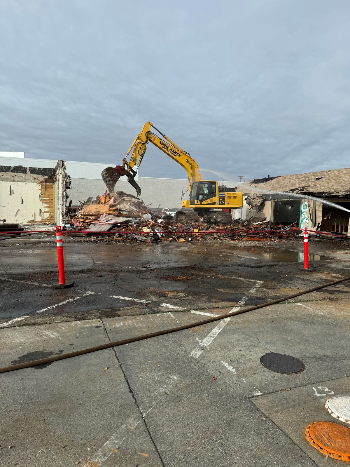 Excavator demolishing commercial building
